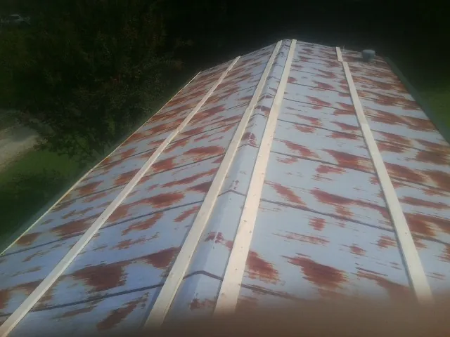 Rusted metal roof panels with new wood purlins before replacement — Storm Damage Roof Repair in Cedar Springs by Roofing Brothers