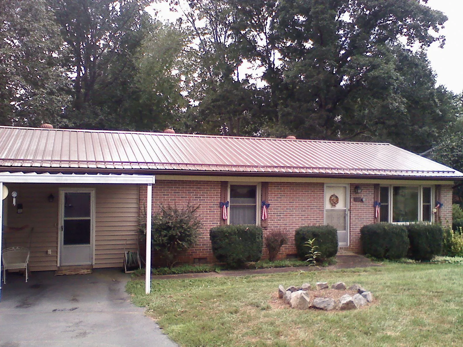 Bronze metal roof and carport on a brick ranch home — Roof Repair work by our crew in Cedar Springs